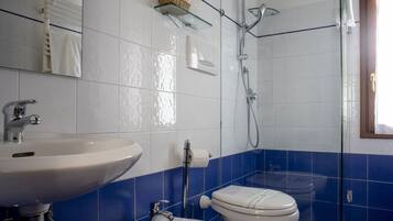 Un baño con lavamanos blanco, inodoro y ducha.