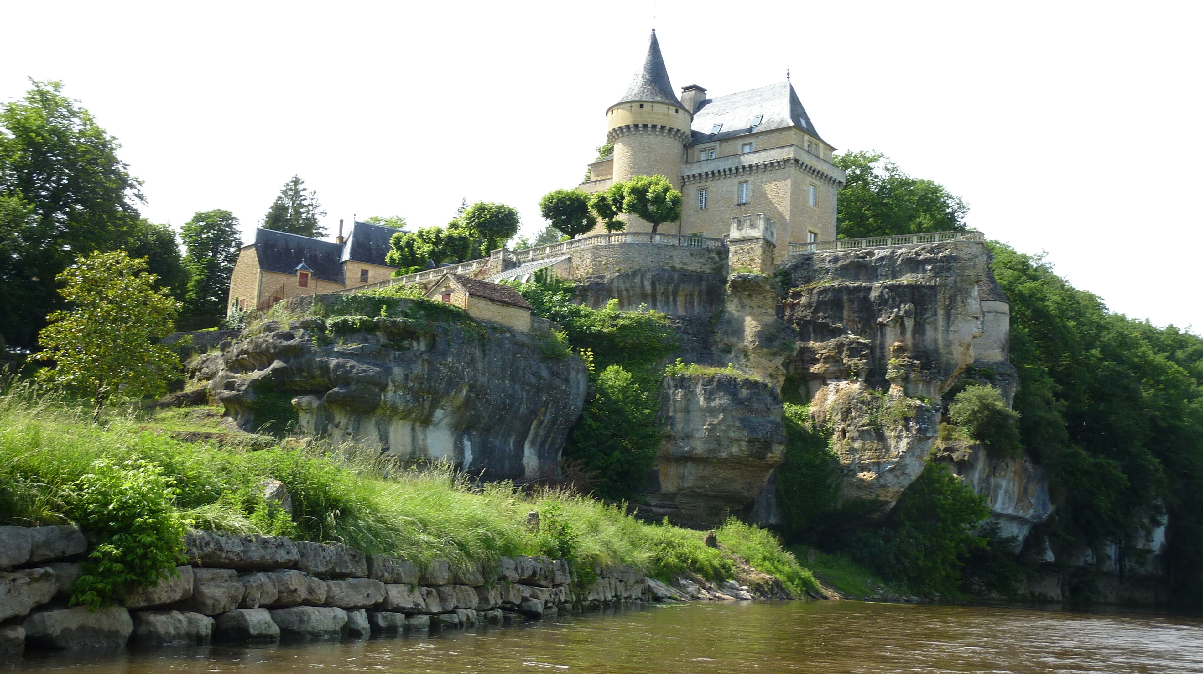 A castle on a cliff by a river.