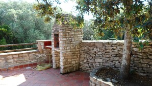 A stone-built outdoor area with a brick floor, a stone wall, and a tree. - Charming villa in the heart of the maquis          (Bonifacio)
