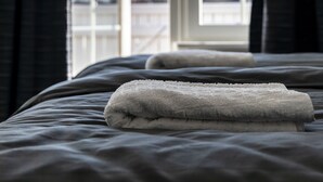 A bedroom with a large bed, a window, and a view of the outdoors. - Business Home Club (Lidköping)
