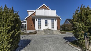 A two-story house with a front porch, a brick facade, and a driveway leading to the entrance. - Business Home Club (Lidköping)