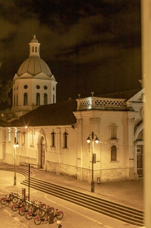 A nighttime view of a historic building with a dome and a bell tower, featuring a series of steps leading up to the entrance. - Hotel Azul de la Plaza (Cuenca)