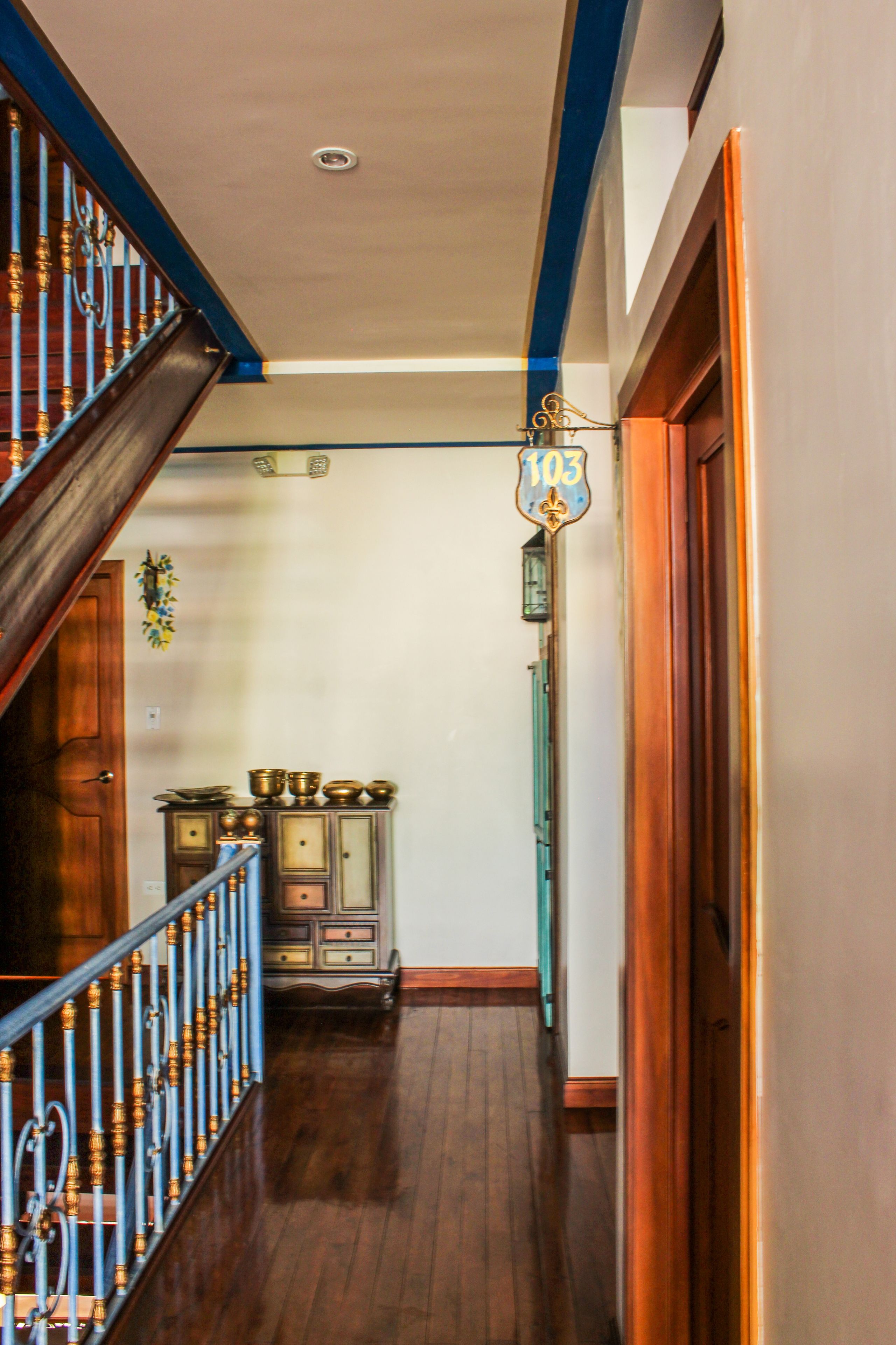 A wooden staircase with blue railings leading to a landing.