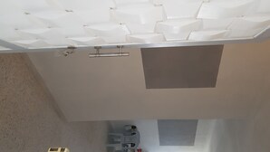 Sostre amb un dibuix geomètric de panells blancs i una lluminària central.