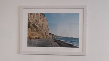 A framed photograph of a coastal landscape with cliffs and the sea.