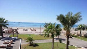 Une vue sur la plage, avec des palmiers et des chaises longues.