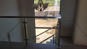 Un escalier avec des rampes en métal et un lustre.