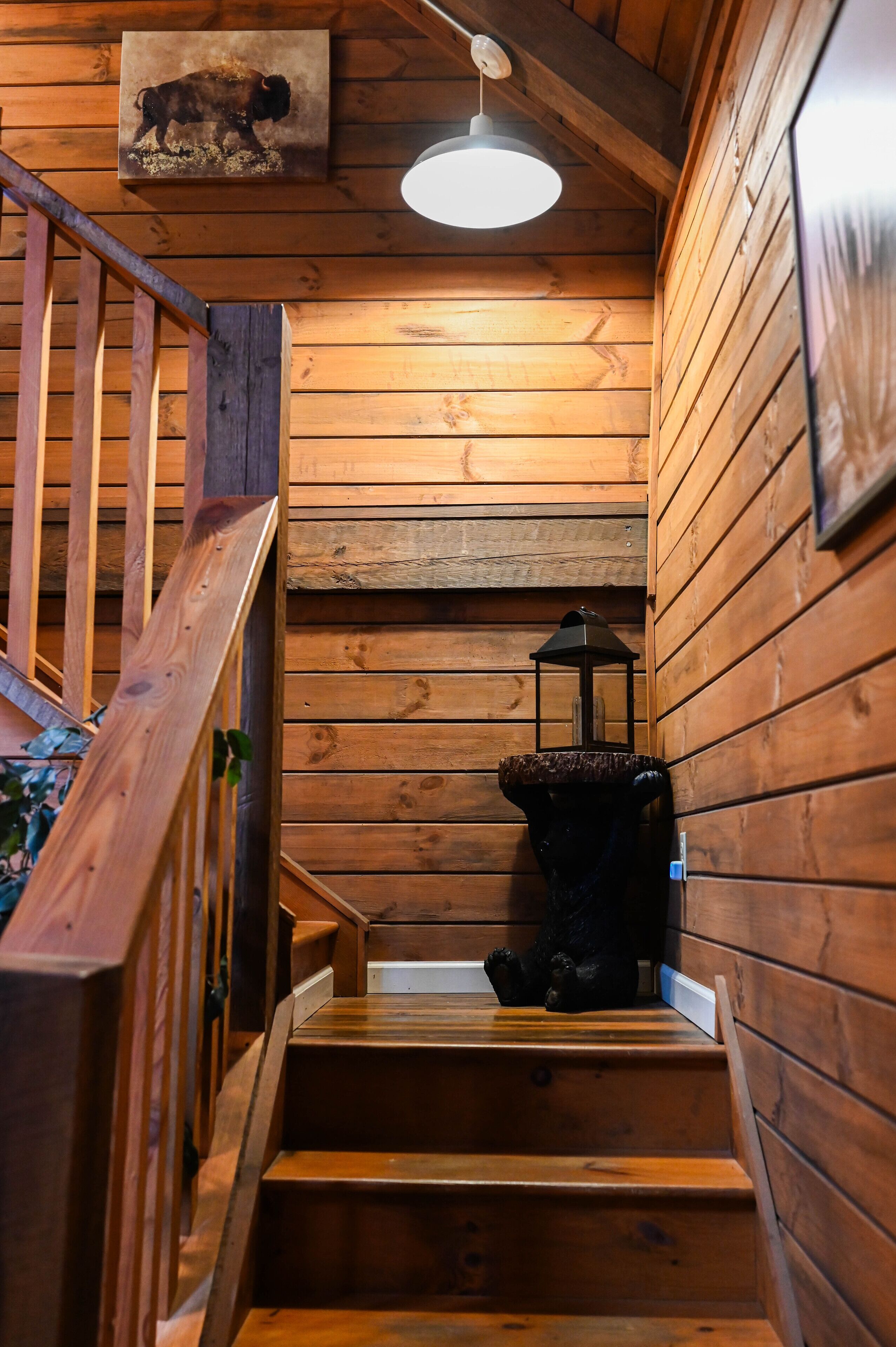 A wooden staircase with a lantern on the landing.