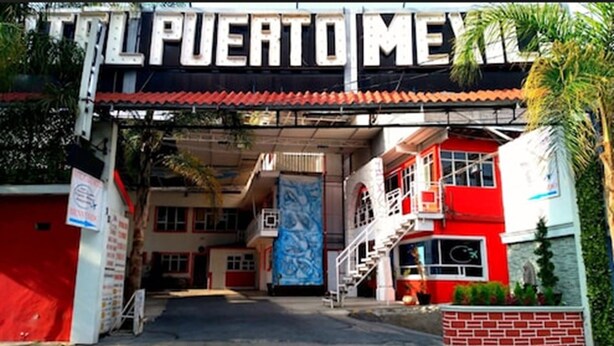 Un bâtiment avec une enseigne indiquant « Puerto Mexico » et une façade rouge et blanche.
