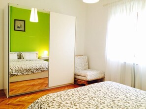 A bedroom with a bed, a chair, a wardrobe, and a mirror. - Apartments Maras (Porec)