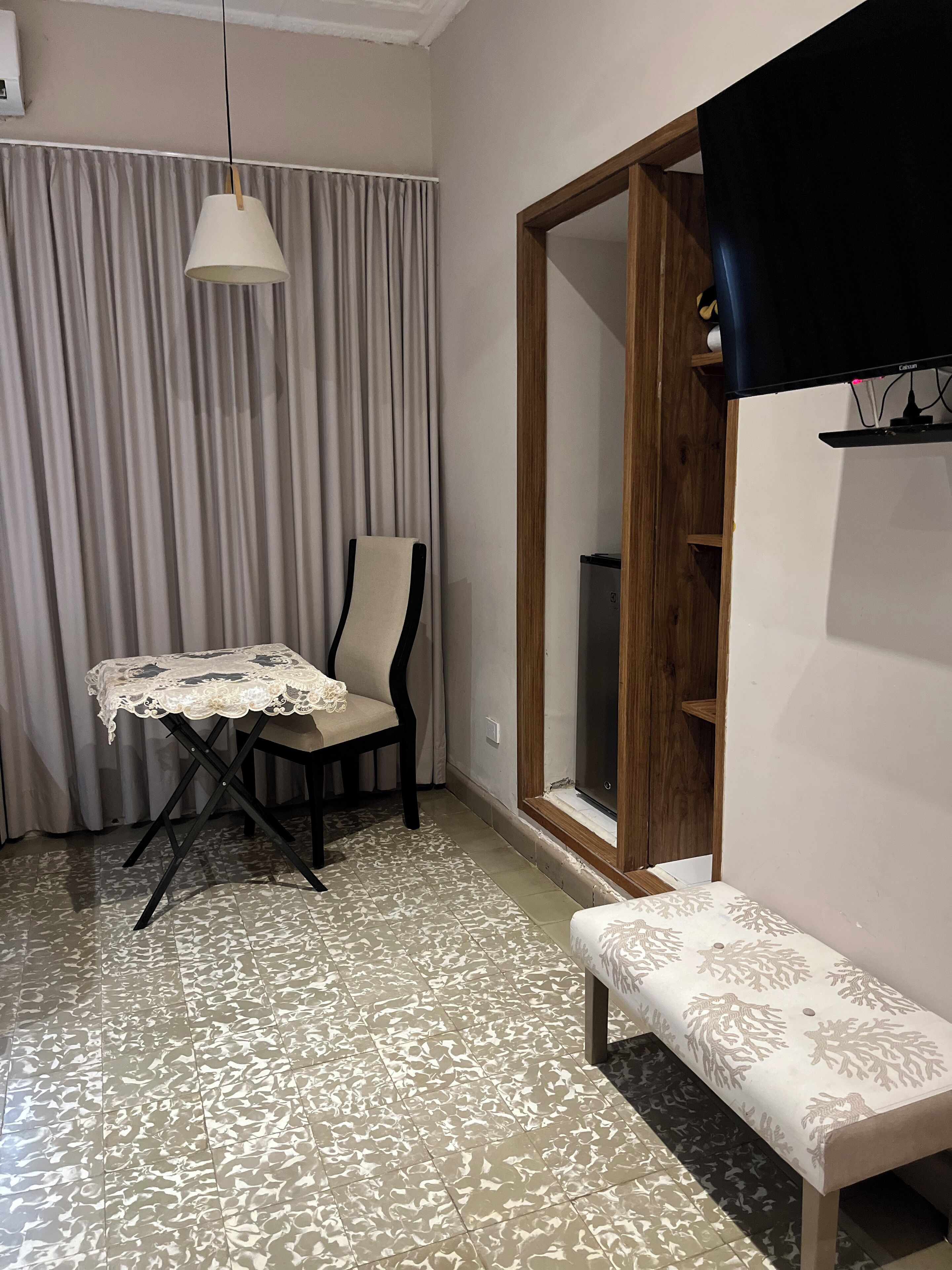Une pièce comprenant une table, une chaise, un banc et une armoire avec un miroir.