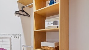 Een inloopkast met houten planken, een kledingroede en een opbergbox.