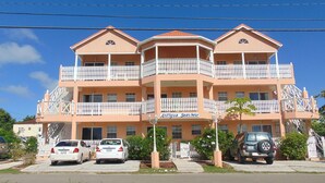 Un hotel a più piani con balconi, un cartello con la scritta "Antigua Seaview" e auto parcheggiate davanti.