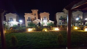 A courtyard with a central building featuring a tower, surrounded by smaller structures. - Diplomats Villa at Diplo4 MV Rass El Hekma (El Dabaa)