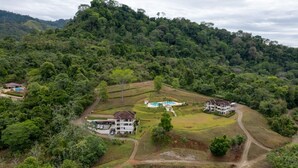 A resort with multiple buildings, a swimming pool, and lush greenery surrounding the property. - Private Garden, Walk Out to Community Pool, Beautiful 1 Bedroom 1 Bath Condo (San Buenas)