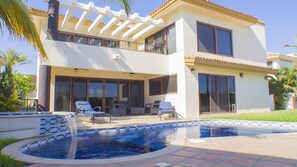 A two-story house with a swimming pool, outdoor seating, and large windows. - Gorgeous 2 1/2 Bedrooms  House with a private pool and a Spectacular View (cabo san lucas)