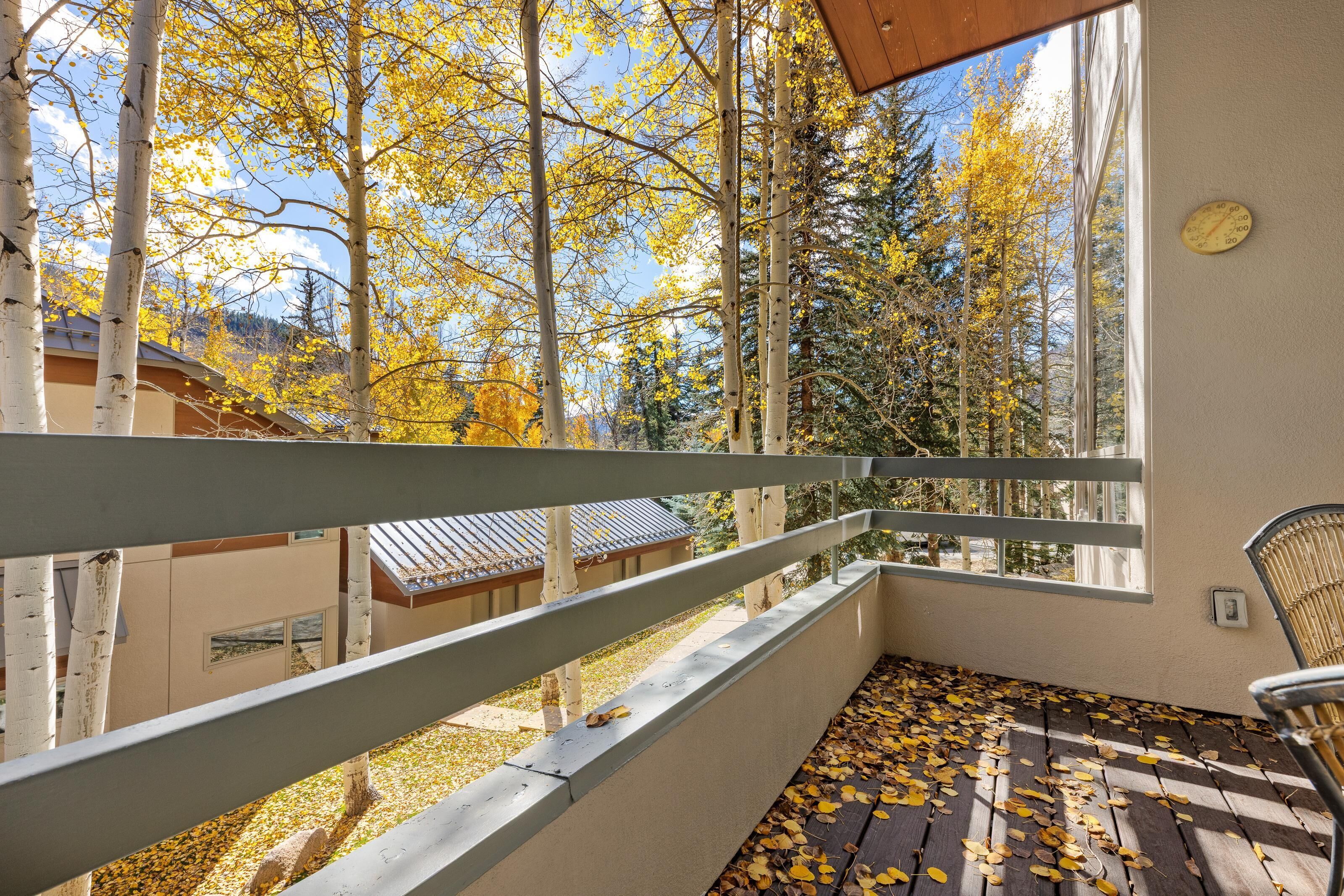 Un balcon donnant sur des arbres et des immeubles.