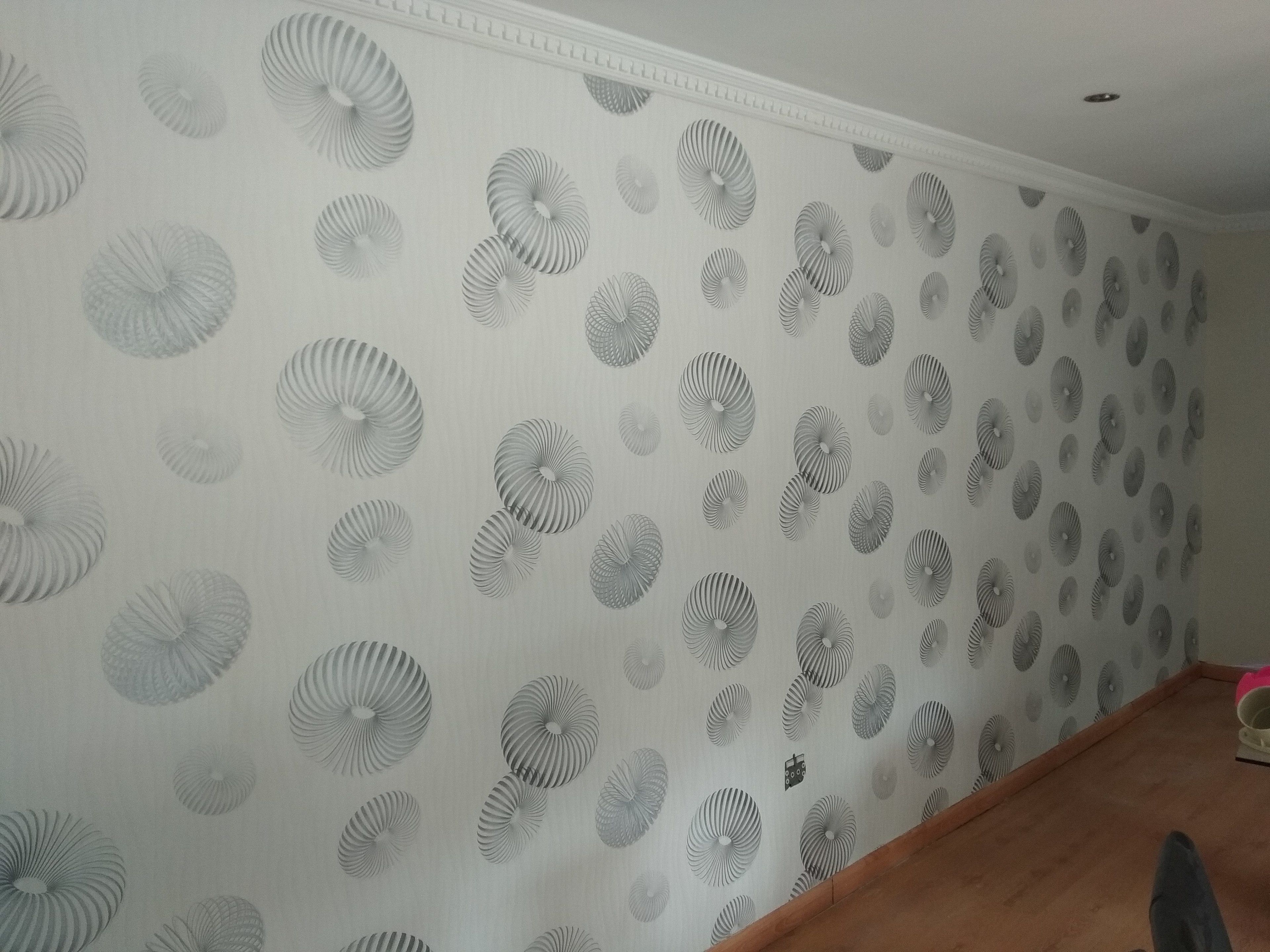 A room with a patterned wallpaper featuring circular designs.