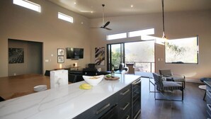 A modern kitchen with a marble countertop, a dining area with a large table, and a seating area with a view of the outdoors. -  Stunning 3 bed, 2 bath home w/Bell Rock and Castle Rock views (Sedona)