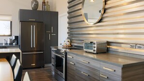 A modern kitchen with stainless steel appliances, a wooden backsplash, and a built-in oven. -  Stunning 3 bed, 2 bath home w/Bell Rock and Castle Rock views (Sedona)
