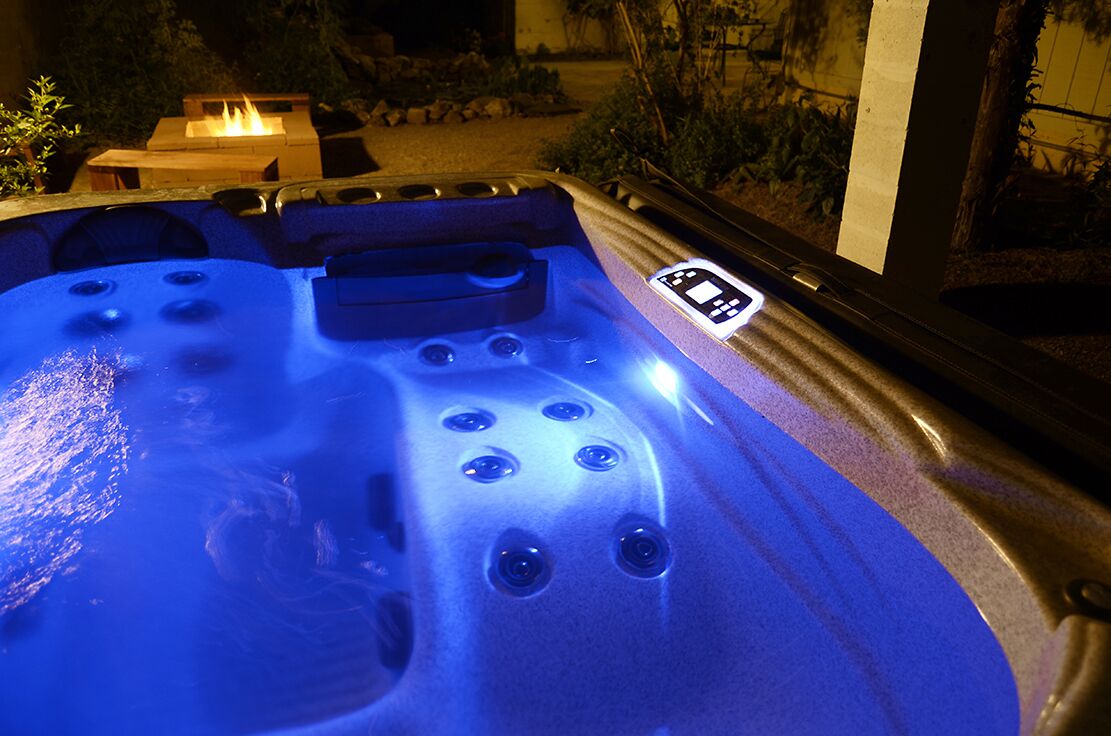 Ein Whirlpool mit Bedienfeld und einem Kamin im Hintergrund.