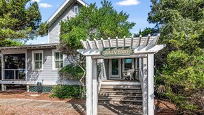 A wooden gazebo with a sign reading "the Balvenie" in front of a house with a porch.