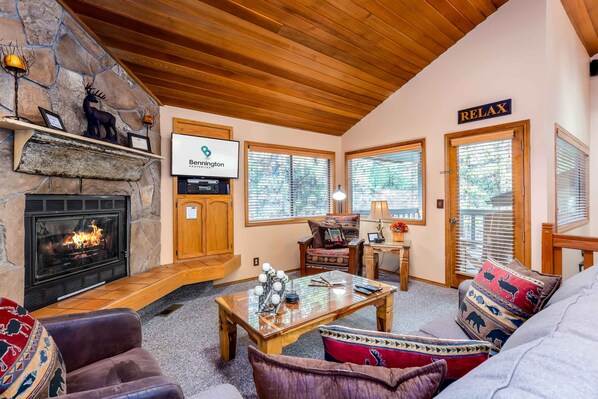 A cozy living room with a stone fireplace, wooden ceiling, and a sign that reads "Relax". - ASHW05 - Charming Home, A/C, Hot Tub, Bikes (Sunriver)