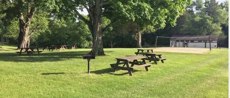 A park with picnic tables and a covered shelter.