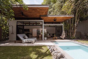Uma casa moderna com piscina, área de estar e espaço para refeições.
