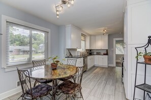 Enjoy meals at the round dining table in this kitchen, which features a central island and ample storage.