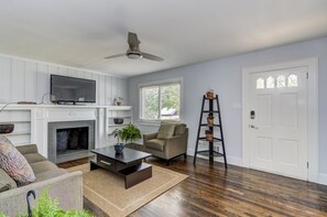 Relax in style with a comfortable sofa, armchair, and fireplace, perfect for unwinding in a peaceful environment.