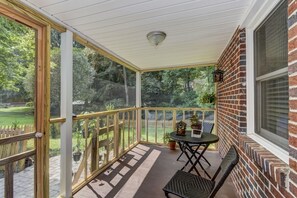 Relax in this serene outdoor space with a brick wall, wooden deck, and comfortable seating area.