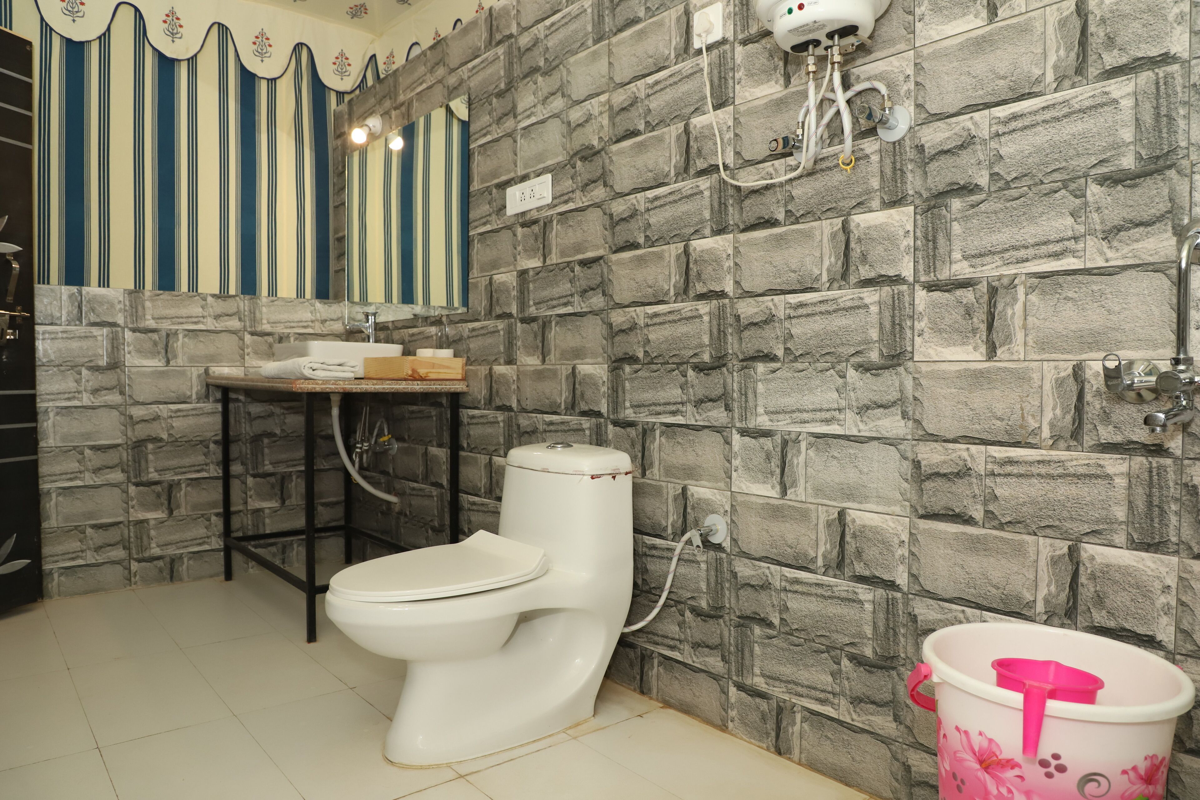 Un baño con inodoro blanco, lavamanos y zona de ducha.