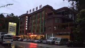 Un hotel de varios pisos con un letrero llamativo en caracteres chinos.