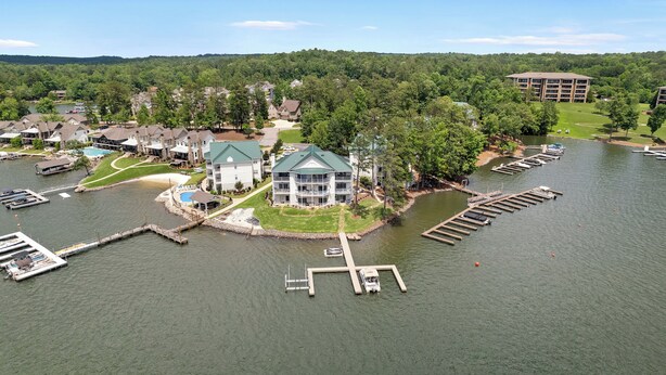 A lakeside property with a large house, a swimming pool, and docked boats. - Lakefront Walkout Condo in StillWaters – Stunning Views & Prime Location! (Dadeville)
