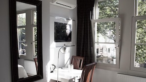 Un coin repas comprenant une table et des chaises, un grand miroir et un téléviseur fixé au mur.