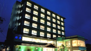 A multi-story hotel with illuminated windows and a green-lit entrance. - Kaisyu (Kyotango)