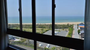 A view from a window overlooking a beach with a parking lot and buildings in the foreground. - Kaisyu (Kyotango)