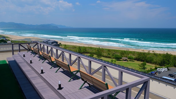 A beach view from a deck with wooden benches and a railing. - Kaisyu (Kyotango)