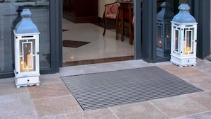 Een moderne gevel met glazen deuren, een klein terras en twee decoratieve lantaarns.