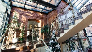 Een modern interieur met een glazen dak, bakstenen muren en een trap.