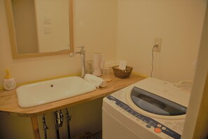 A bathroom with a sink, mirror, and washing machine. - Mountain Home Lodge in Deer Park (Nara)
