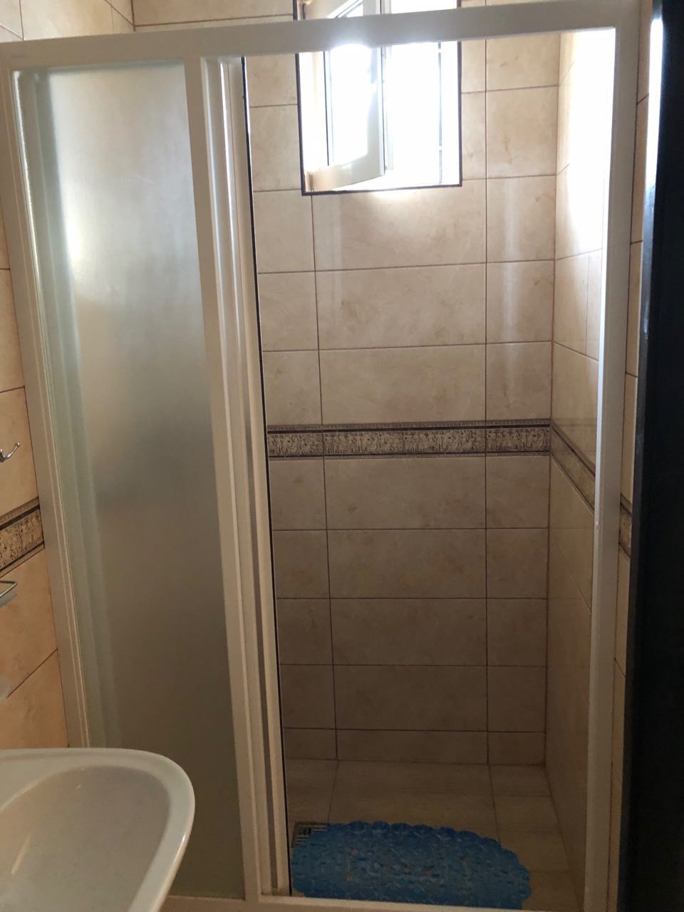 Ein Badezimmer mit Duschkabine, Badewanne und Fenster.