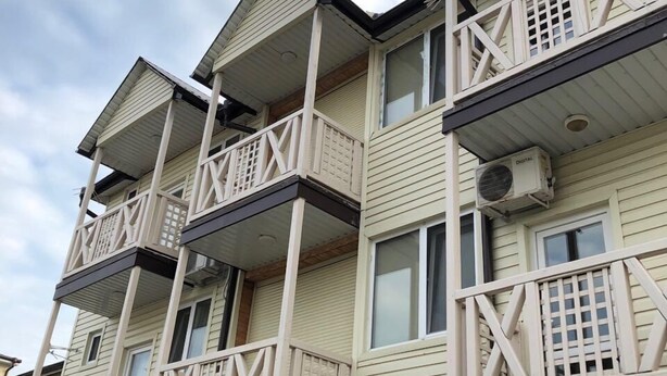Un immeuble à plusieurs étages doté de balcons et de climatiseurs.