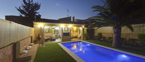 Una piscina al aire libre, sillones reclinables de piscina