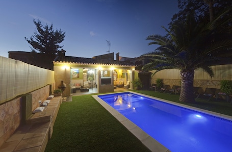 Una piscina al aire libre, sillones reclinables de piscina