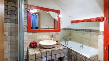 Un baño con bañera, lavamanos y ducha.