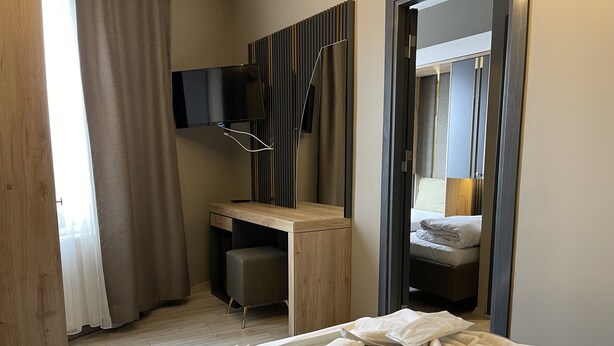 A hotel room with a bed, a desk, a chair, a television, and a mirror. - New Taksim  (Istanbul)
