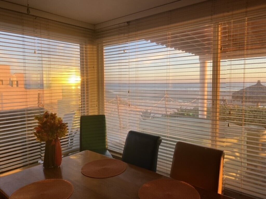 A dining area with a table, chairs, and a vase of flowers.