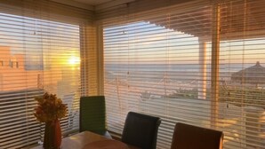 Un coin repas avec une table, des chaises et un vase de fleurs.